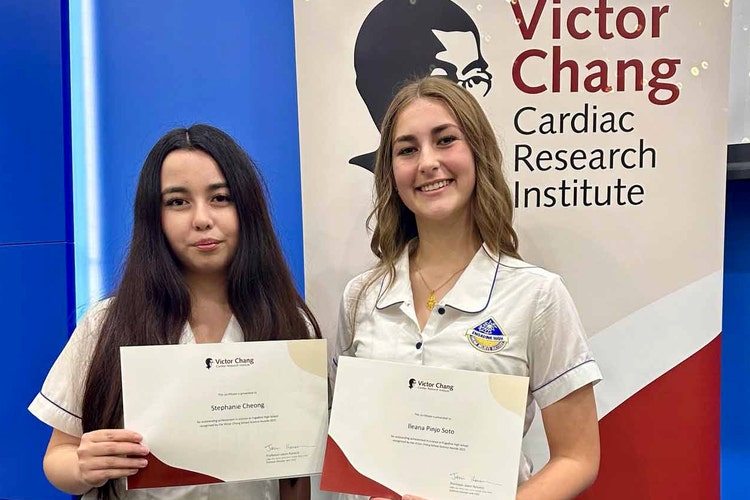 Students standing with awards for Victor Chang