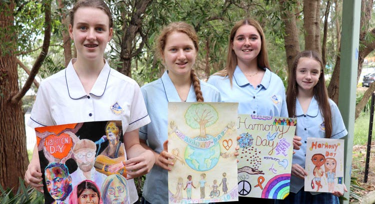 Student holding there design for harmony day posters