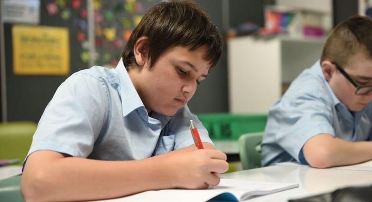 Student writing in classroom